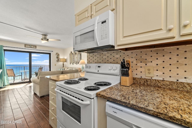 kitchen featuring ceiling fan, white appliances, cream cabinets, a water view, and backsplash