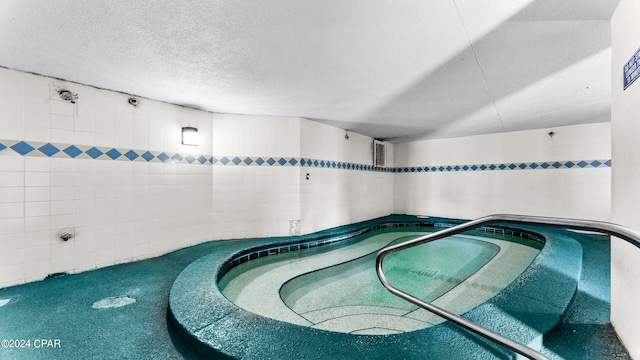 view of pool with an indoor hot tub