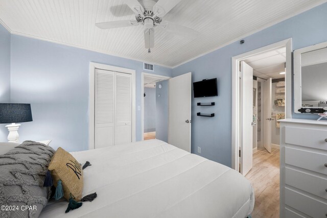 bedroom with light hardwood / wood-style floors, a closet, ceiling fan, and crown molding