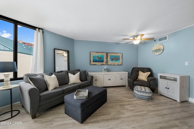 living room with floor to ceiling windows, ceiling fan, and light hardwood / wood-style flooring