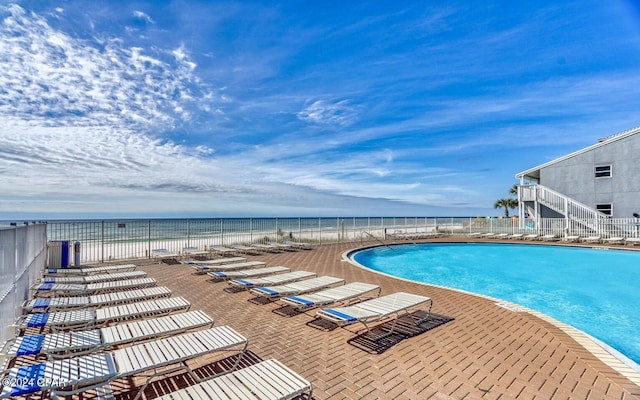 view of swimming pool with a patio and a water view