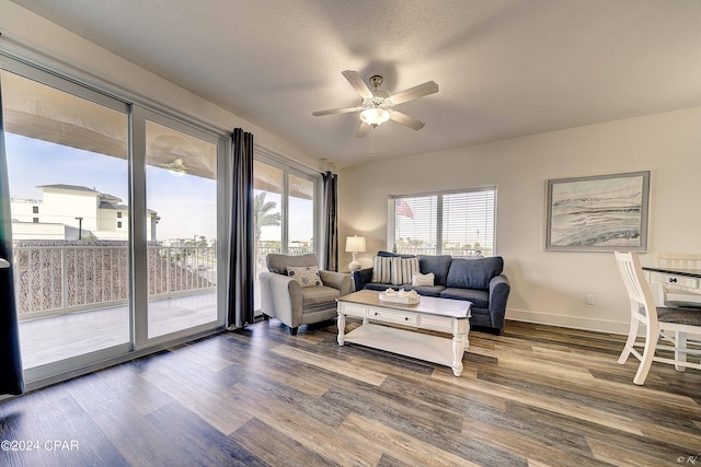 living room with ceiling fan, dark hardwood / wood-style floors, and a textured ceiling