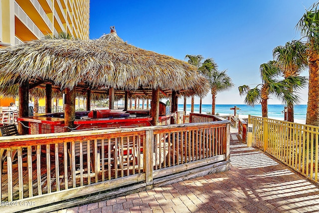 wooden terrace featuring a water view and a gazebo