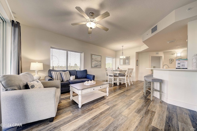 living room featuring hardwood / wood-style floors and ceiling fan