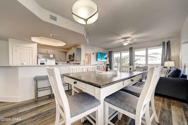 dining area featuring ceiling fan and dark hardwood / wood-style flooring