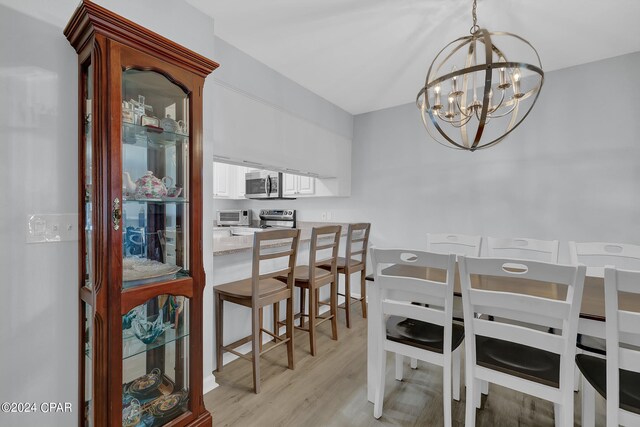 dining area featuring a notable chandelier and light hardwood / wood-style floors