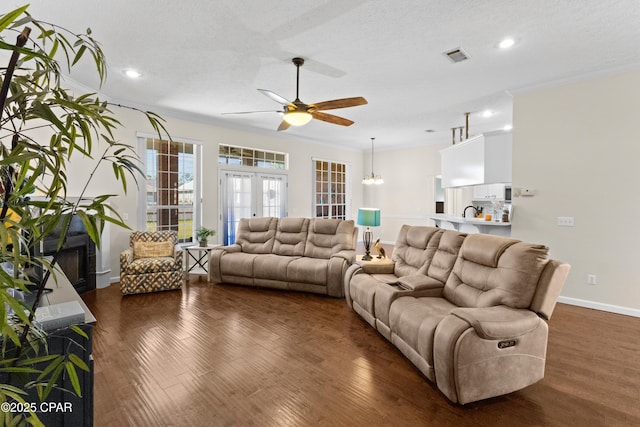 living room with french doors, dark wood-type flooring, and crown molding