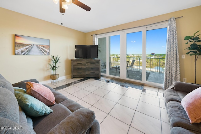 living area featuring tile patterned flooring, ceiling fan, and baseboards