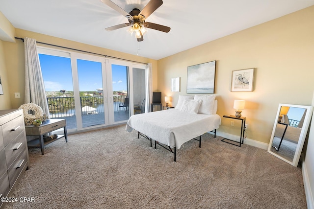 bedroom featuring access to exterior, ceiling fan, baseboards, a water view, and carpet flooring