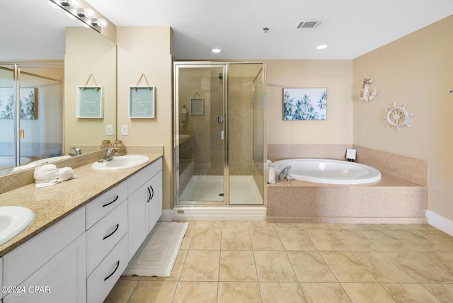 bathroom with tile patterned flooring, double vanity, a stall shower, and a sink