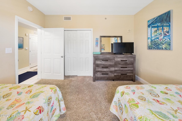 bedroom with a closet, visible vents, baseboards, and carpet