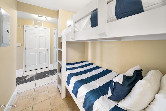 bedroom with electric panel, baseboards, and visible vents