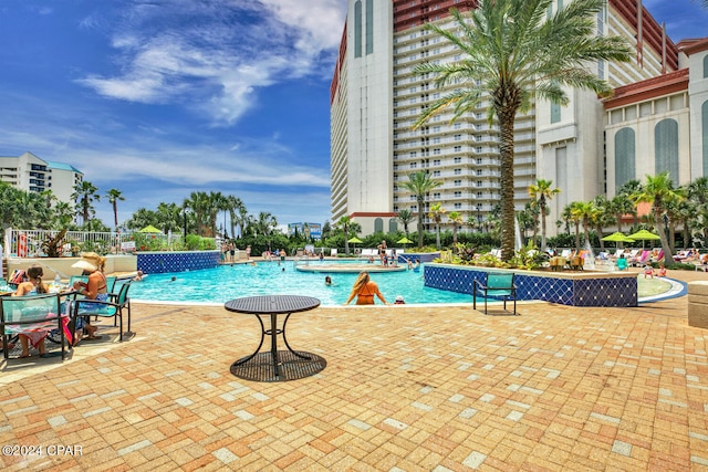 community pool featuring a patio and fence