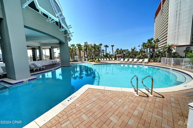 view of swimming pool with pool water feature and a patio