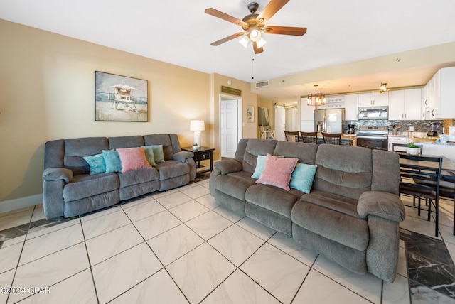 living area featuring ceiling fan with notable chandelier, visible vents, and baseboards