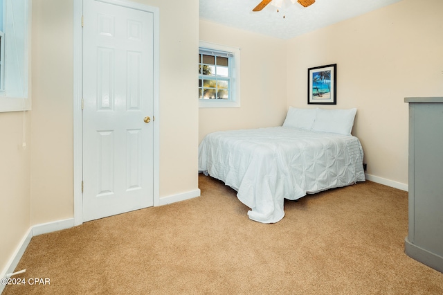 bedroom featuring light carpet and ceiling fan