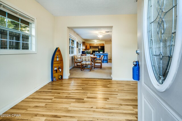 entrance foyer with a textured ceiling and light hardwood / wood-style floors