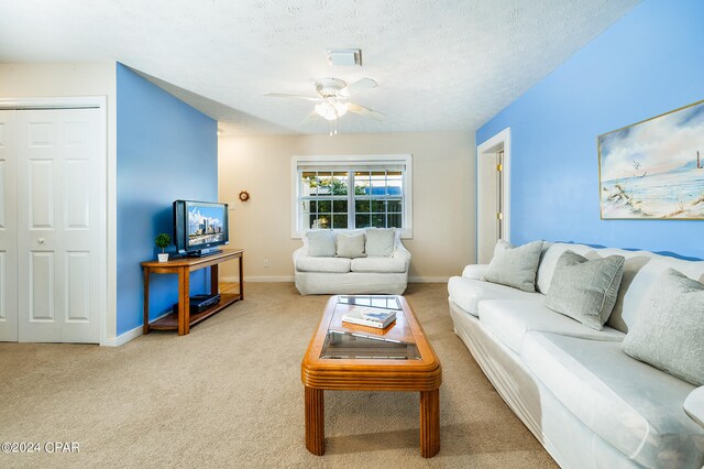 living room featuring a textured ceiling, carpet, and ceiling fan