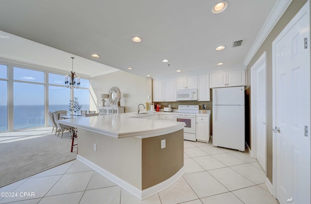 kitchen with a sink, crown molding, a breakfast bar area, white appliances, and white cabinets