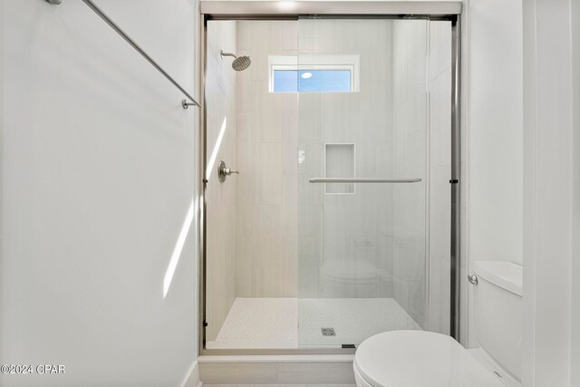 bathroom with an enclosed shower and toilet