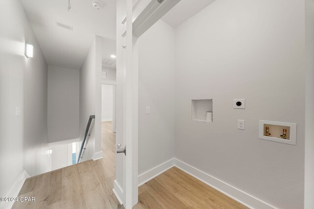 laundry room with washer hookup, electric dryer hookup, and light hardwood / wood-style floors