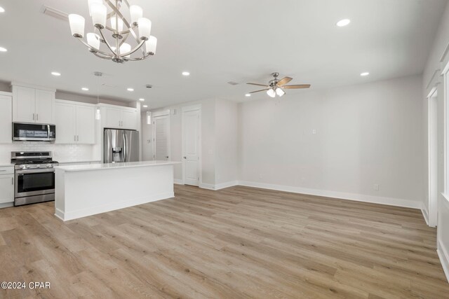 kitchen featuring hanging light fixtures, appliances with stainless steel finishes, light hardwood / wood-style floors, ceiling fan with notable chandelier, and a center island