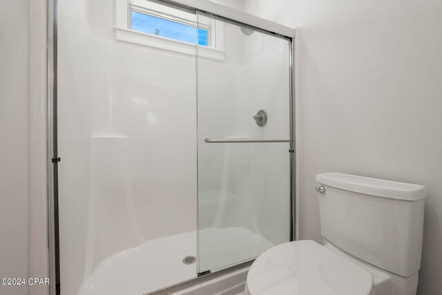 bathroom with walk in shower and toilet