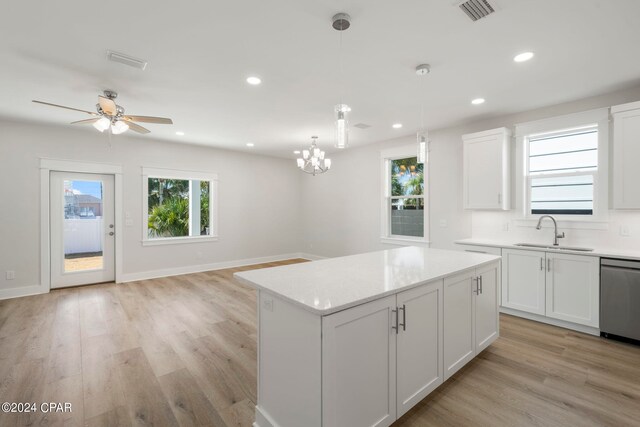 kitchen with white cabinets, light wood-type flooring, sink, and pendant lighting