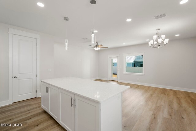 kitchen featuring a center island, decorative light fixtures, ceiling fan with notable chandelier, white cabinets, and light wood-type flooring