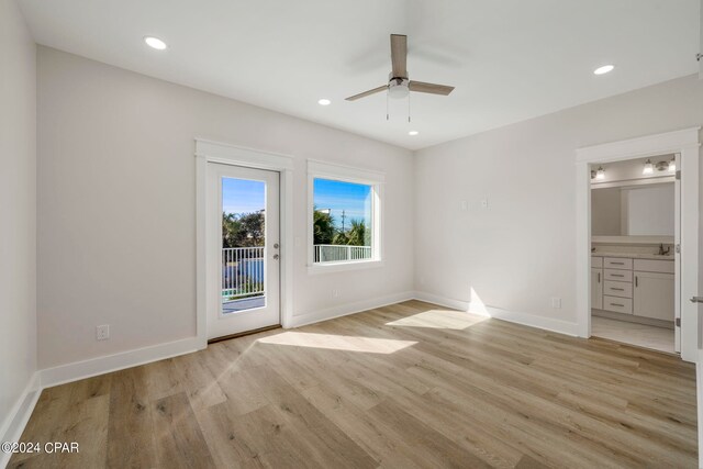 unfurnished room with ceiling fan, light wood-type flooring, and sink