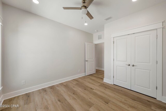 unfurnished bedroom with a closet, ceiling fan, and light wood-type flooring