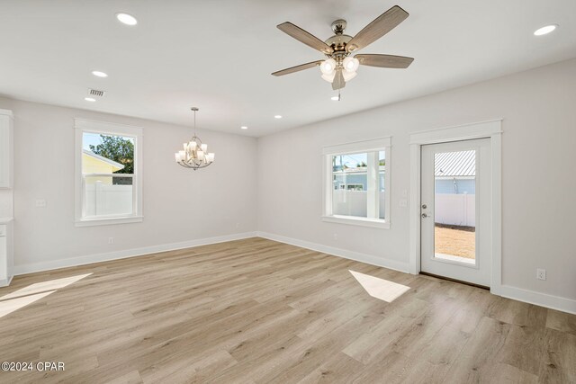 spare room featuring light hardwood / wood-style floors and ceiling fan with notable chandelier