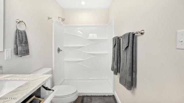 bathroom featuring walk in shower, vanity, and toilet