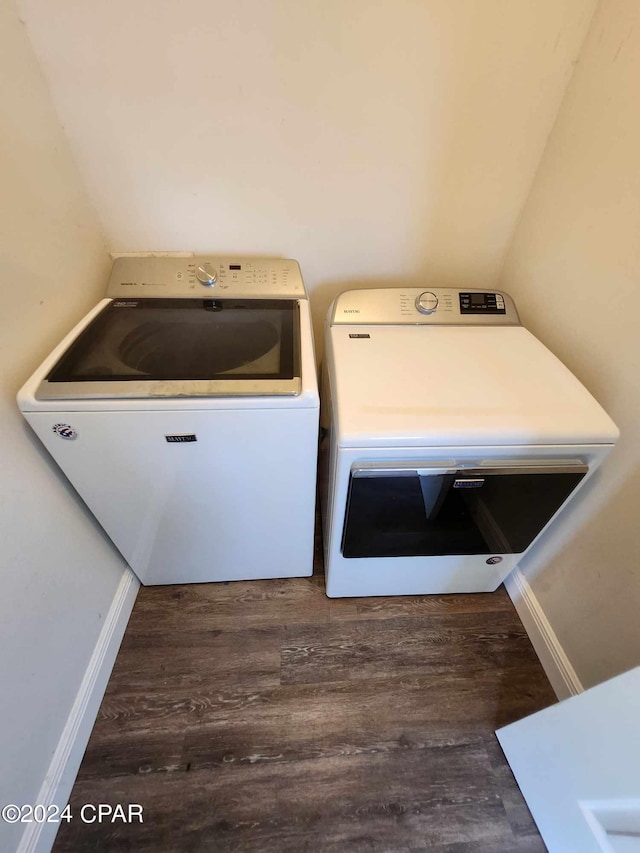 clothes washing area with independent washer and dryer and dark wood-type flooring