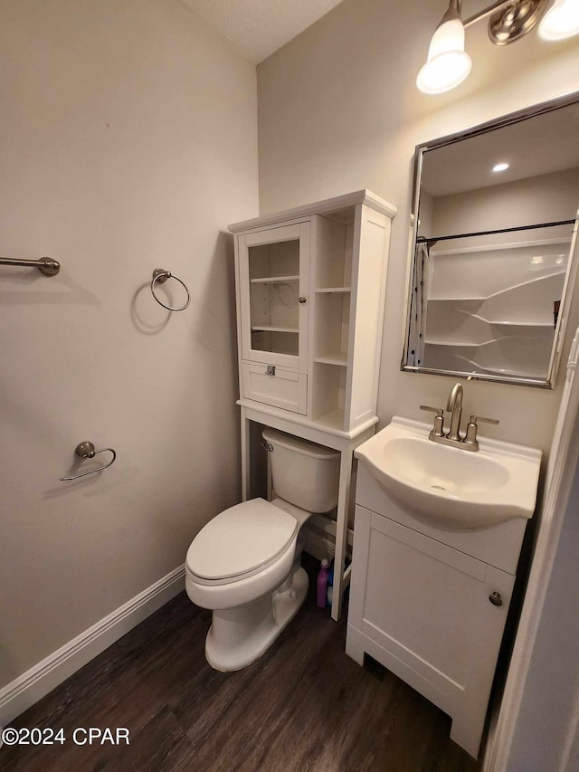 bathroom with vanity, hardwood / wood-style flooring, toilet, and curtained shower