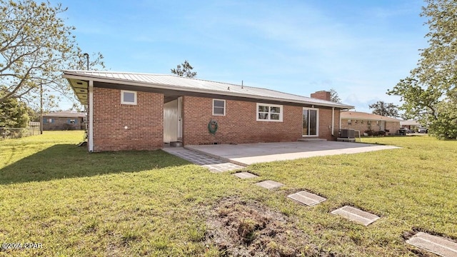 back of house featuring a lawn, central AC, and a patio area