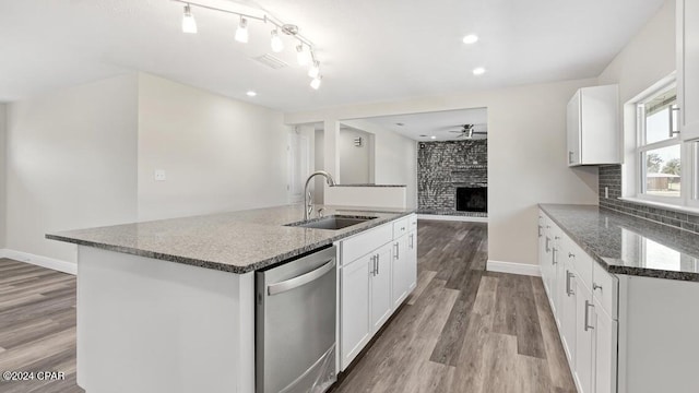 kitchen featuring sink, a center island with sink, white cabinetry, dishwasher, and light hardwood / wood-style floors