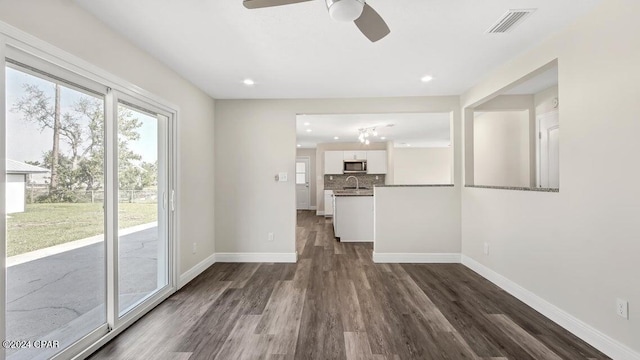 unfurnished living room with ceiling fan and dark hardwood / wood-style flooring