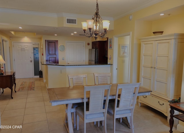 dining area with crown molding, light tile flooring, and an inviting chandelier