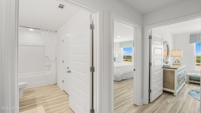 ensuite bathroom with visible vents, toilet, wood finished floors, connected bathroom, and vanity