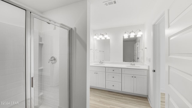 full bathroom featuring a stall shower, wood finished floors, visible vents, and a sink