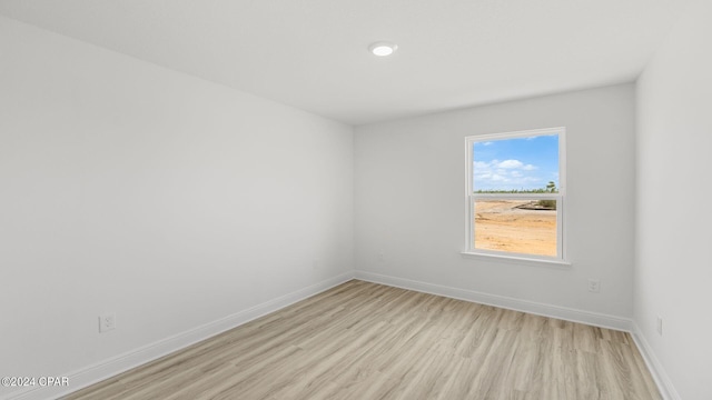 unfurnished room featuring light wood finished floors and baseboards