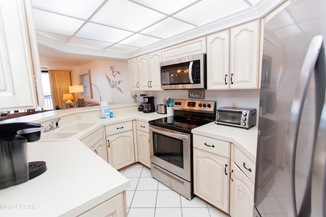 kitchen with kitchen peninsula, cream cabinets, appliances with stainless steel finishes, light tile patterned flooring, and sink