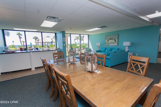 carpeted dining room with a drop ceiling