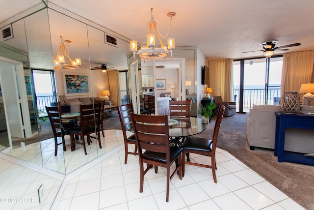 dining area with floor to ceiling windows, light tile patterned flooring, and ceiling fan with notable chandelier