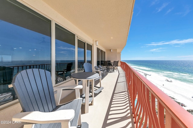 balcony featuring a beach view and a water view