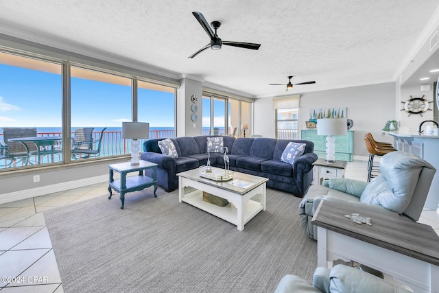 tiled living room featuring ceiling fan, a textured ceiling, sink, and ornamental molding