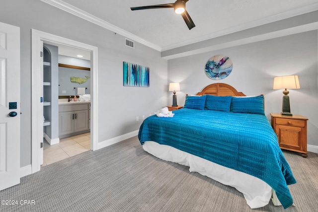 bedroom featuring light carpet, ornamental molding, ceiling fan, and ensuite bath