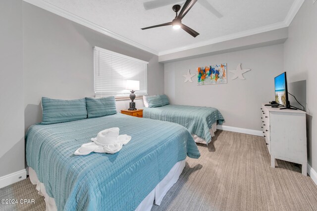 carpeted bedroom with ceiling fan and ornamental molding