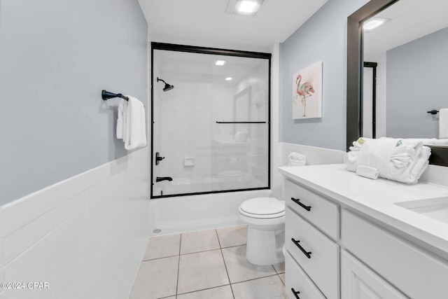 full bathroom featuring tile floors, tiled shower / bath, toilet, and vanity